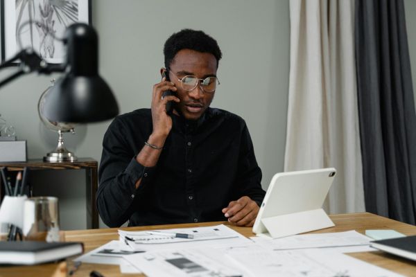 Casually dressed man smiling while using a laptop at home